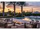 Relaxing poolside patio area featuring a modern fire pit, comfortable seating, and lush landscaping at 9148 N 66Th Pl, Paradise Valley, AZ 85253