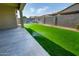 Backyard features artificial grass, a covered patio, desert landscaping, and an in-ground sprinkler at 9738 E Tumeric Ave, Mesa, AZ 85212