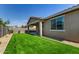 Home features a low-maintenance backyard with artificial grass, covered patio and desert landscaping at 9738 E Tumeric Ave, Mesa, AZ 85212