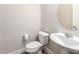 Well-lit bathroom features a pedestal sink, toilet, and modern fixtures at 9738 E Tumeric Ave, Mesa, AZ 85212