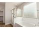 Bright bathroom with soaking tub, glass enclosed shower, and wood look floors at 9738 E Tumeric Ave, Mesa, AZ 85212