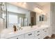 Bathroom featuring double vanity, white cabinets, framed mirror, and wood look floors at 9738 E Tumeric Ave, Mesa, AZ 85212
