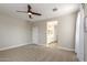 Spacious carpeted bedroom featuring ceiling fan, neutral paint, and access to ensuite bathroom at 9738 E Tumeric Ave, Mesa, AZ 85212