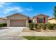 Charming single-story home featuring a well-maintained yard, red window shutters, and a two-car garage at 9738 E Tumeric Ave, Mesa, AZ 85212