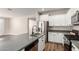 Open-concept kitchen with white cabinetry, gray countertops, and stainless steel appliances at 9738 E Tumeric Ave, Mesa, AZ 85212