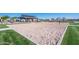 Outdoor sand volleyball court with covered seating area, surrounded by grassy lawn at 9738 E Tumeric Ave, Mesa, AZ 85212