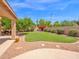 The serene backyard features a lush lawn, colorful flowers, and a tranquil seating area for outdoor relaxation at 981 N Quail Ln, Gilbert, AZ 85233