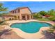 This spacious backyard offers a sparkling pool with a rock garden, a covered patio, and ample room for recreation at 981 N Quail Ln, Gilbert, AZ 85233