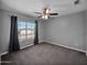 Bedroom offers neutral carpet, window with dark drapes and ceiling fan at 981 N Quail Ln, Gilbert, AZ 85233
