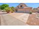 Desert landscaped home featuring a clay tile roof, three-car garage, and mature shade trees at 981 N Quail Ln, Gilbert, AZ 85233