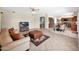 Spacious living room boasts tile flooring, a leather ottoman, and seamless flow into the kitchen and dining area at 981 N Quail Ln, Gilbert, AZ 85233