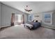 Spacious main bedroom with high ceilings, large windows and neutral color tones with a ceiling fan at 981 N Quail Ln, Gilbert, AZ 85233