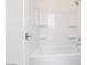 Clean white bathroom featuring a shower-tub combination and built-in shelves at 10013 S 36Th Ave, Laveen, AZ 85339