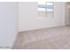 Neutral carpeted bedroom with a window and white door providing a calm atmosphere at 10013 S 36Th Ave, Laveen, AZ 85339