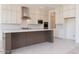 Spacious kitchen featuring white cabinets, a contrasting dark island and stainless steel appliances at 10013 S 36Th Ave, Laveen, AZ 85339
