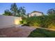Private backyard with stone patio and illuminated shrubbery at 10141 E Floriade Dr, Scottsdale, AZ 85260