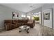 A spacious living room features a comfortable brown couch, a coffee table and lots of natural light at 10141 E Floriade Dr, Scottsdale, AZ 85260