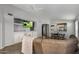 A living room with gray walls has hardwood floors, an entertainment center, and is open to the kitchen at 10141 E Floriade Dr, Scottsdale, AZ 85260