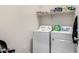 Functional laundry room with a modern washer and dryer, including overhead shelving at 1254 E Thomas Dr, Casa Grande, AZ 85122