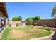 Beautifully landscaped backyard with mature trees, privacy fence, and patio, offering a serene outdoor space at 14938 W Mauna Loa Ln, Surprise, AZ 85379