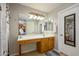 Bathroom featuring white vanity with knee cutout and decorative sconces at 14938 W Mauna Loa Ln, Surprise, AZ 85379