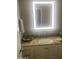 Bright bathroom features granite counters, vanity, and modern illuminated mirror at 14938 W Mauna Loa Ln, Surprise, AZ 85379