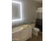 Bathroom with a vanity, illuminated mirror, and toilet with tiled floors at 14938 W Mauna Loa Ln, Surprise, AZ 85379