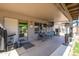 Large covered patio features an outdoor dining area with a television and ceiling fan for comfortable gatherings at 14938 W Mauna Loa Ln, Surprise, AZ 85379