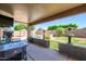 A spacious, covered patio with outdoor seating and a view of the backyard swimming pool and patio at 14938 W Mauna Loa Ln, Surprise, AZ 85379