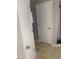 Hallway with closed doors to various rooms with tiled floors at 14938 W Mauna Loa Ln, Surprise, AZ 85379