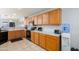 Kitchen with wood cabinets, tile floors, light countertops and black appliances at 14938 W Mauna Loa Ln, Surprise, AZ 85379