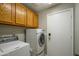 Laundry room with washer, dryer and wooden cabinets at 14938 W Mauna Loa Ln, Surprise, AZ 85379