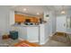 View of kitchen with wood cabinets and breakfast bar from living room at 14938 W Mauna Loa Ln, Surprise, AZ 85379