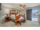 Bedroom with wood furniture set, ceiling fan, and view of the outdoor pool at 14938 W Mauna Loa Ln, Surprise, AZ 85379