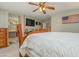 Bedroom with decorative wood furniture, ceiling fan, and view of ensuite bath at 14938 W Mauna Loa Ln, Surprise, AZ 85379