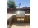 Well-equipped outdoor kitchen featuring a built-in grill, perfect for hosting summer barbecues at 14938 W Mauna Loa Ln, Surprise, AZ 85379