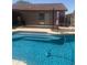 Sparkling in-ground pool with clear blue water and a cleaning device visible in the water at 14938 W Mauna Loa Ln, Surprise, AZ 85379