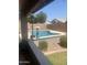 Inviting backyard pool with lush greenery and comfortable outdoor seating area for relaxation at 14938 W Mauna Loa Ln, Surprise, AZ 85379
