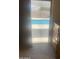 View of a refreshing swimming pool visible through the sliding glass door and a dresser to the right at 14938 W Mauna Loa Ln, Surprise, AZ 85379