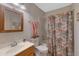 Traditional bathroom with shower-tub combo and sink with a warm wooden framed mirror at 1559 S Padre Rd, Apache Junction, AZ 85119