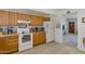 Cozy kitchen features white appliances, wood cabinets and a dining area beyond at 1559 S Padre Rd, Apache Junction, AZ 85119