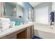 Well-lit bathroom with a window, a bathtub, and a spacious vanity area at 16441 N 138Th Ave, Surprise, AZ 85374