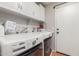 Bright laundry room with white cabinets, front load washer and dryer, and ample shelving at 16441 N 138Th Ave, Surprise, AZ 85374