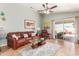 Comfortable living room featuring tile floors, a ceiling fan, and access to the backyard, ideal for relaxing and entertaining at 16441 N 138Th Ave, Surprise, AZ 85374