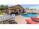 Backyard oasis with a sparkling pool, brick patio, covered seating, and dining area at 16441 N 138Th Ave, Surprise, AZ 85374