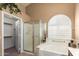 Bathroom featuring glass shower, tub with shutters, and neutral decor at 17585 N Coyote Lakes Pkwy, Surprise, AZ 85378