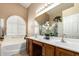 Well-lit bathroom with dual sinks, tub, and modern plantation shutters at 17585 N Coyote Lakes Pkwy, Surprise, AZ 85378