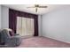 Comfortable bedroom features plantation shutters, a chair, and a ceiling fan at 17585 N Coyote Lakes Pkwy, Surprise, AZ 85378