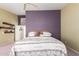 Cozy bedroom showcasing a floral quilt, soft lighting, and built-in shelving at 17585 N Coyote Lakes Pkwy, Surprise, AZ 85378