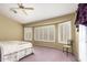 Bright bedroom featuring plantation shutters, neutral walls, and a comfy floral quilt at 17585 N Coyote Lakes Pkwy, Surprise, AZ 85378